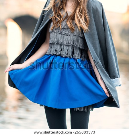 woman street fashion look with blue skirt, jacket, dress and black tights
