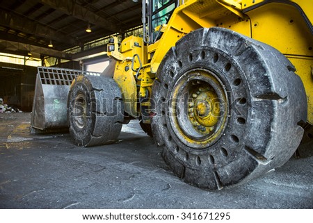Heavy duty construction digger yellow excavator with big wheels working on the plant