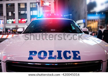 A police car rushes to the emergency call with lights turned on in the city street