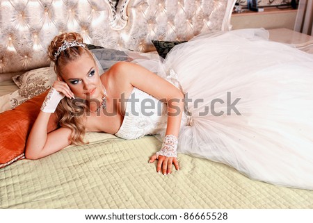 stock photo Bride lying on a bed in a wedding dress on their wedding night