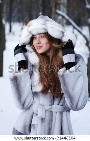 Portrait of woman in winter landscape with snow flakes.