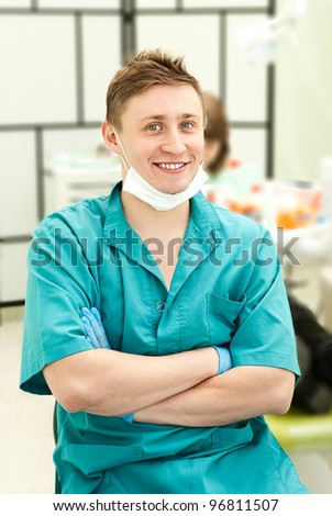 Portrait of a happy dental doctor smiling with dental office in the background