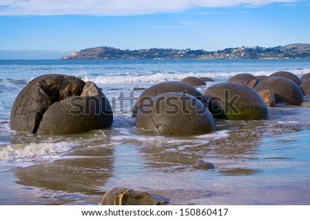 Moeraki balls on the coast of New Zealand while the tide comes in.
