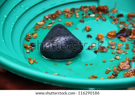 Sample of pebble of graphite ore against a flushing tray