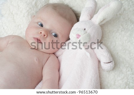 Adorable Baby Lying On Soft Furry Blanket Cuddling With Pink Toy 