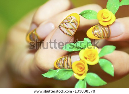 Acrylic nails with threads in the style of a French manicure with acrylic yellow roses.