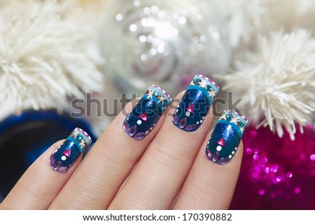 Winter Blue Manicure With Snowflakes And Pink Triangular Rhinestones Near The White Tree And Colorful Shiny Balls .