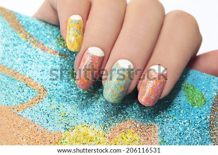 Pastel manicure with different colors of paint and coating in the form of colored stripes.