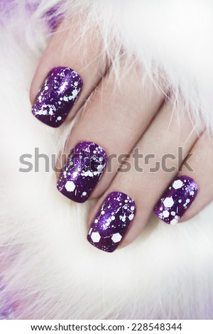 Lilac nail Polish lacquer with snow crumb on the nails of the girl.