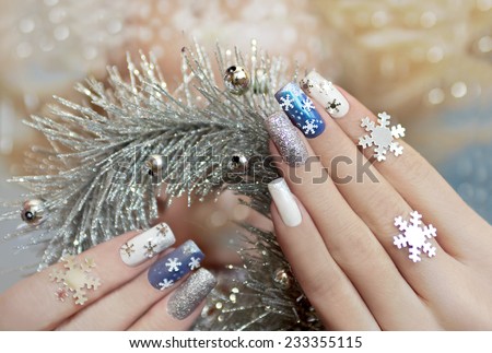 Manicure with snowflakes on your nails with colored lacquers on a rectangular shaped nails.