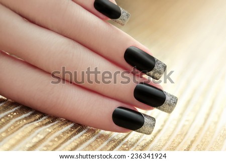 Black French manicure on Golden striped background.