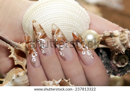 Design with small shells inside the nail and white flourishes .