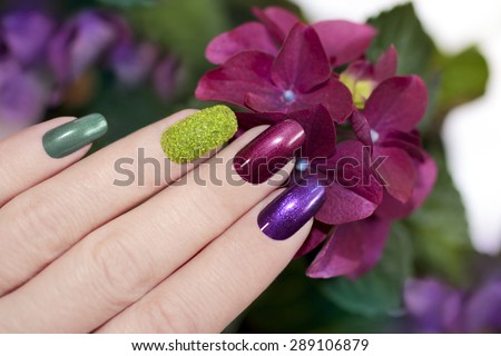 Nail designs with colored sand and dark pearlescent varnishes artificial nails.
