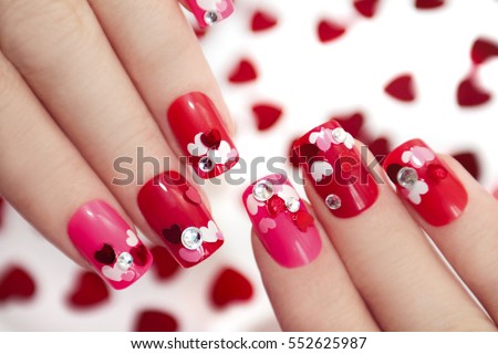 Nail designs with different sequins in the shape of hearts on red and pink nails for girls.