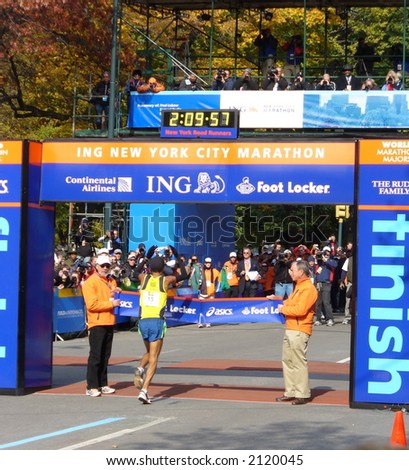New York City Mayor Michael Bloomberg holds the finish line tape as Marilson Gomes dos Santos of Brazil finishes first in the 2006 ING New York City Marathon