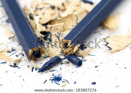 Blue broken pencil and shavings isolated on white background