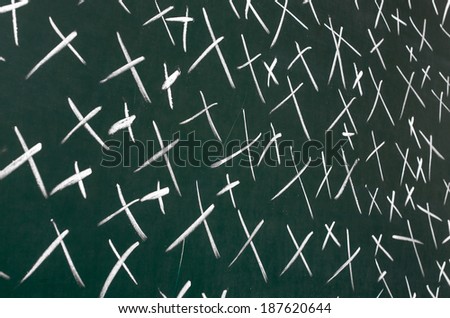 On blackboard with chalk drawn a lot of crosses