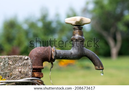 A old rusty water tap in garden.