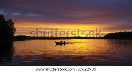 A couple in a little boat during sunset at Lake Ilgis, Plateliai, Lithuania