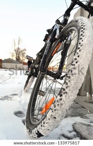 Sports bike close up. Front wheel is covered with snow. St.Petersburg, Russia.