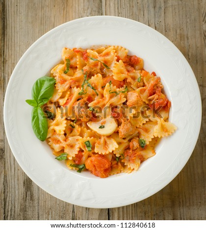 Farfalle pasta topped with tomato sauce, tuna, garlic and basil - Italian cuisine