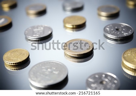 Various coins on reflective surface, close-up