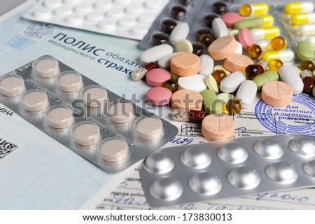 The tablets, the thermometer on the background of medical insurance and prescription close
