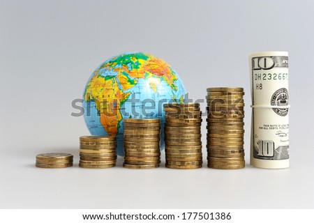 Five stacks of coins with globe and bundle of money on gray background