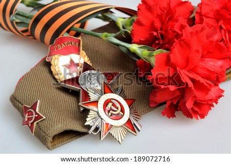 Military cap with red flowers, Saint George ribbon and orders of Great Patriotic war on gray