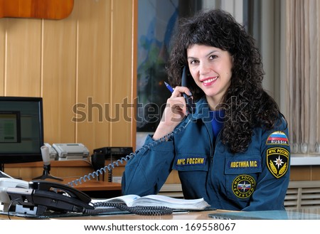 Russian operator of fire protection. Girl in the workplace talking on the phone