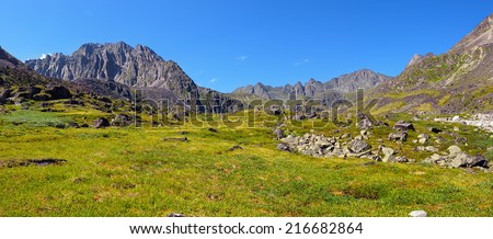 Mountain tundra at noon in July. Dinosaur Peak (left). Sayan mountains. Republic of Buryatia