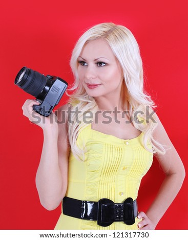 girl with camera over red background, beautiful photographer