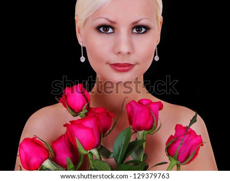 girl with roses, beautiful smiling young woman with bouquet of red flowers over black background, portrait