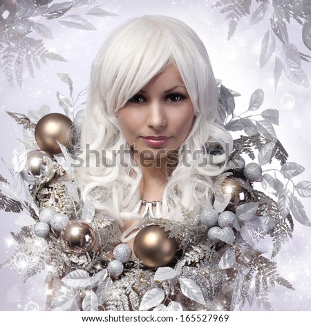Christmas or Winter Woman. Snow Queen. Portrait of Fashion Girl with Silver and Gold Christmas Balls over Snowflakes background. Holiday  Card