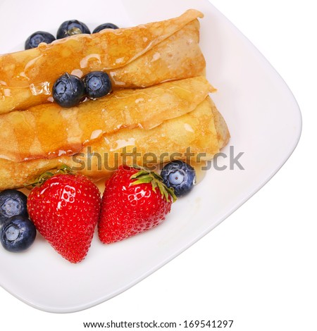 Crepes with Berries. Rolled Pancakes with Strawberry, Blueberry and Honey topping.