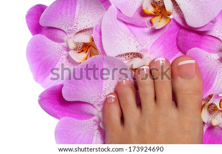 Pedicure with pink orchid flower. Beautiful female foot with french manicure. Foot care. Spa