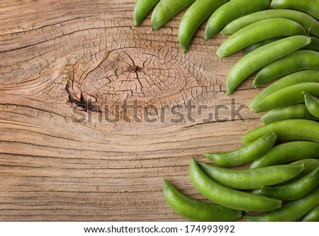 Fresh green pea pods on Wooden Background, with the space for the text