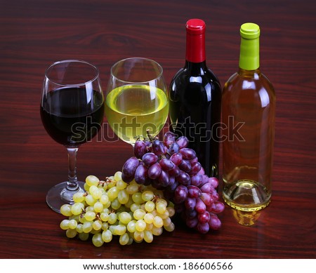 Bottles of Red and White Wine with Fresh Grapes. Glasses of Wine on the table