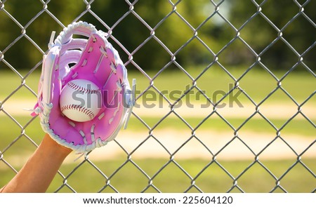 Hand of Baseball Player with Pink Glove and Ball over Field and Net