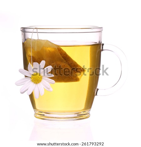 Cup of chamomile tea with chamomile flower and tea bag isolated on white