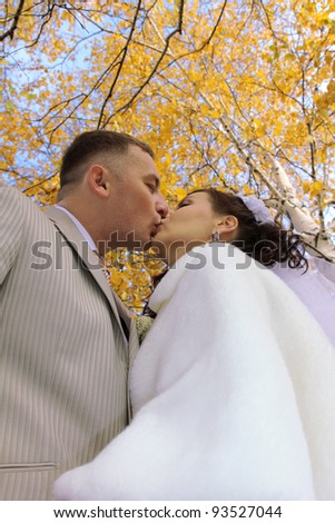 Wedding kiss in autumn park