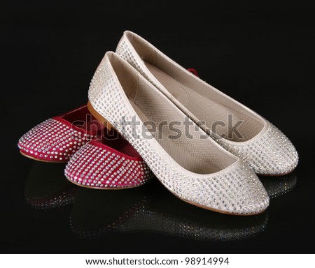 crystals encrusted beige and red flat shoes on black background