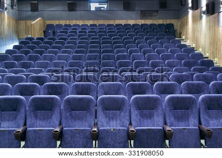 Interior room with lots of blue theater chairs.