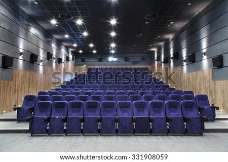 Interior cinema hall with plenty of seating and a projector.