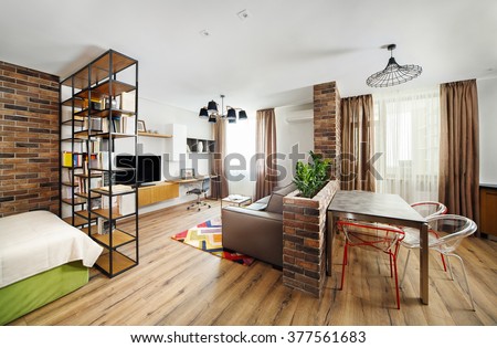 Interior studio apartments, with bookshelves and hardwood floors.