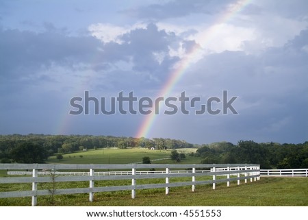 A country landscape with two rainbows accenting the sky during a break in the weather.