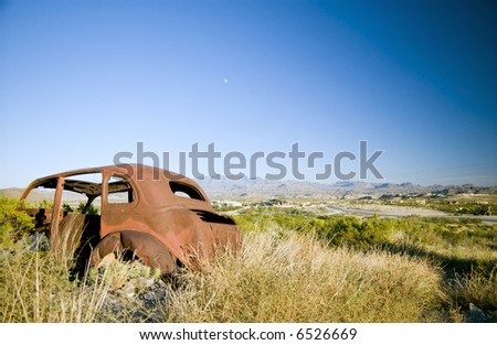 An old, long abandoned vehicle, rusting away in a very rugged, harsh environment.