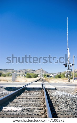 Railroad tracks running through a small town surrounded by a harsh arid environment.