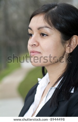 A young woman gazing off into the distance with a pensive look on her face.
