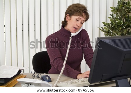 A woman working at her computer in multi-tasking mode.